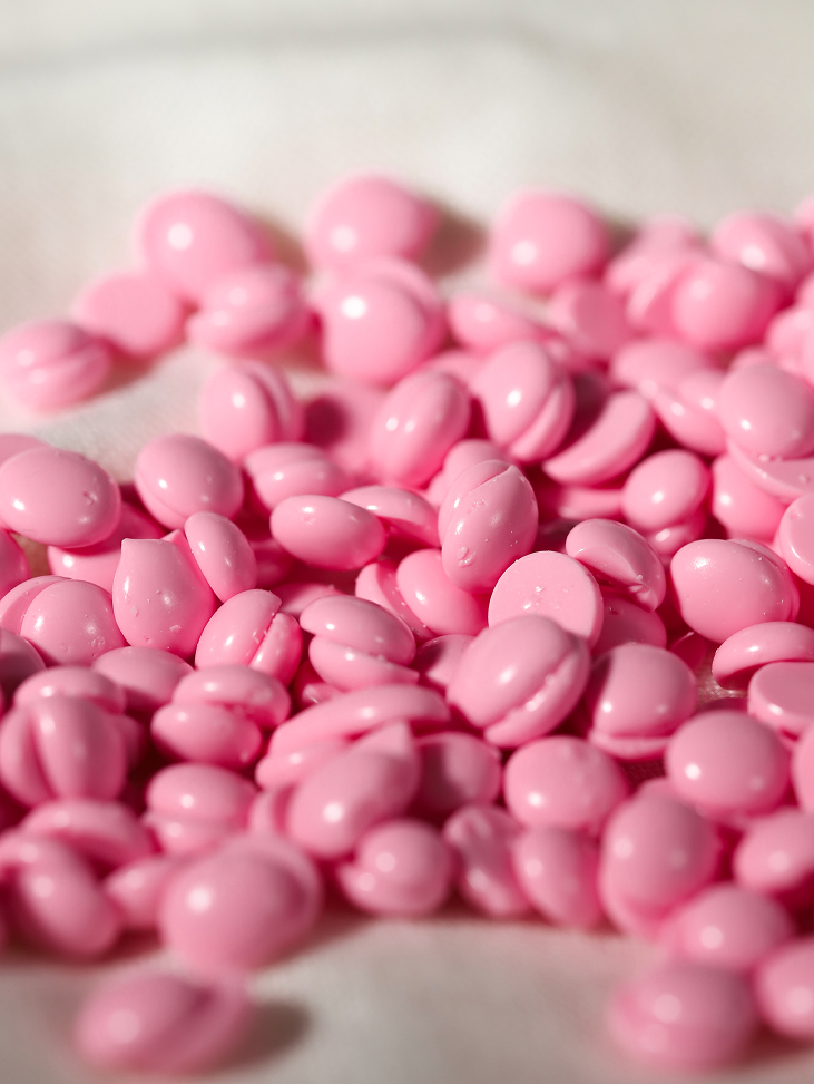 Macro of pink Plumeria wax with short hairs embedded in it